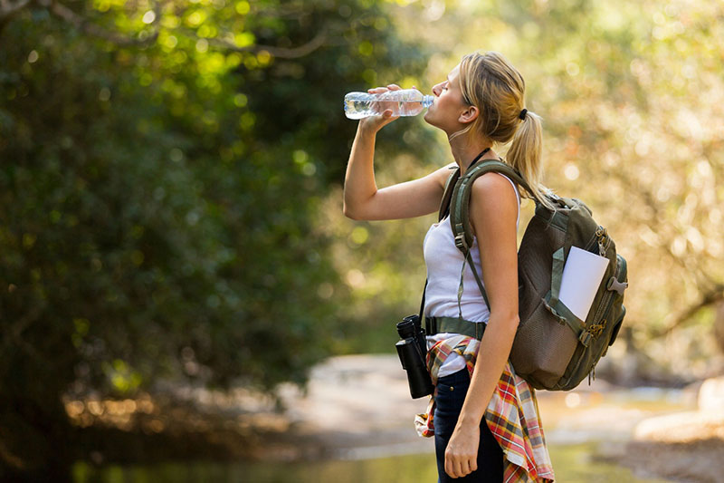 young hiker drinking water